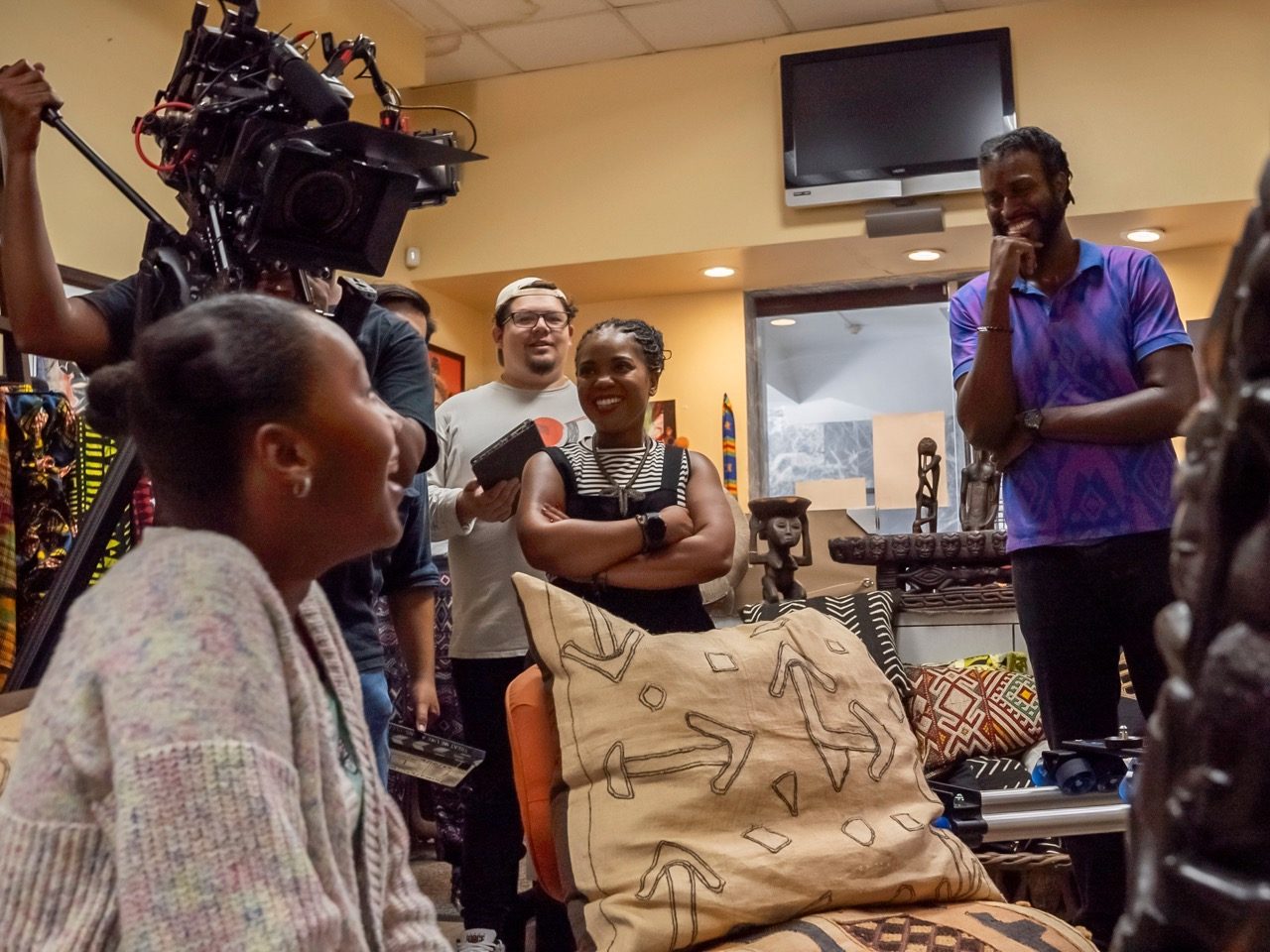 Crew and participants together on set between takes, everyone relaxed and talking