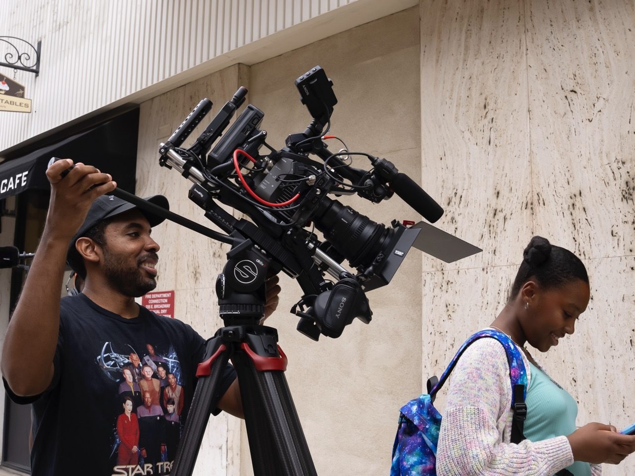 David operating camera on location while a participant waits
